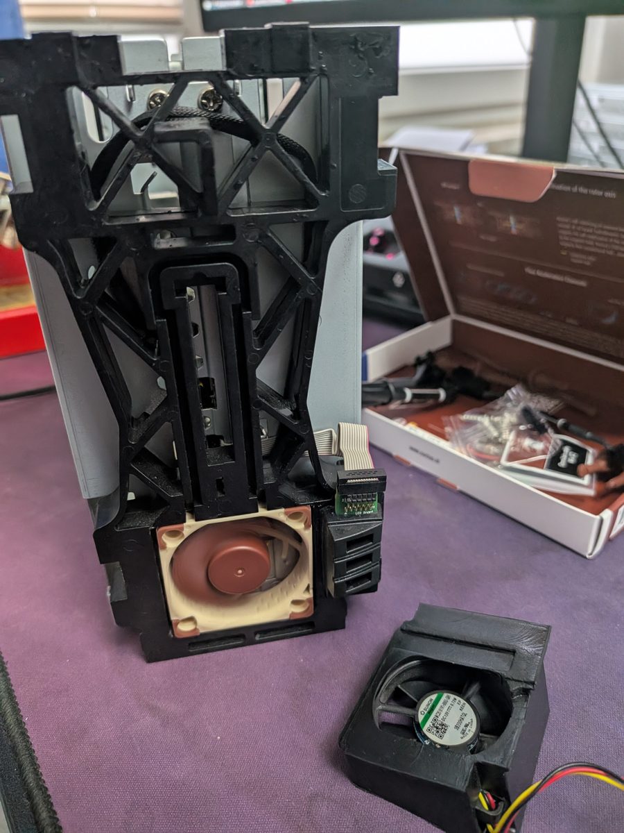 Noctua-Lüfter eingebaut im Plattenrahmen der EX2 Ultra, daneben der ausgebaute Original-Lüfter